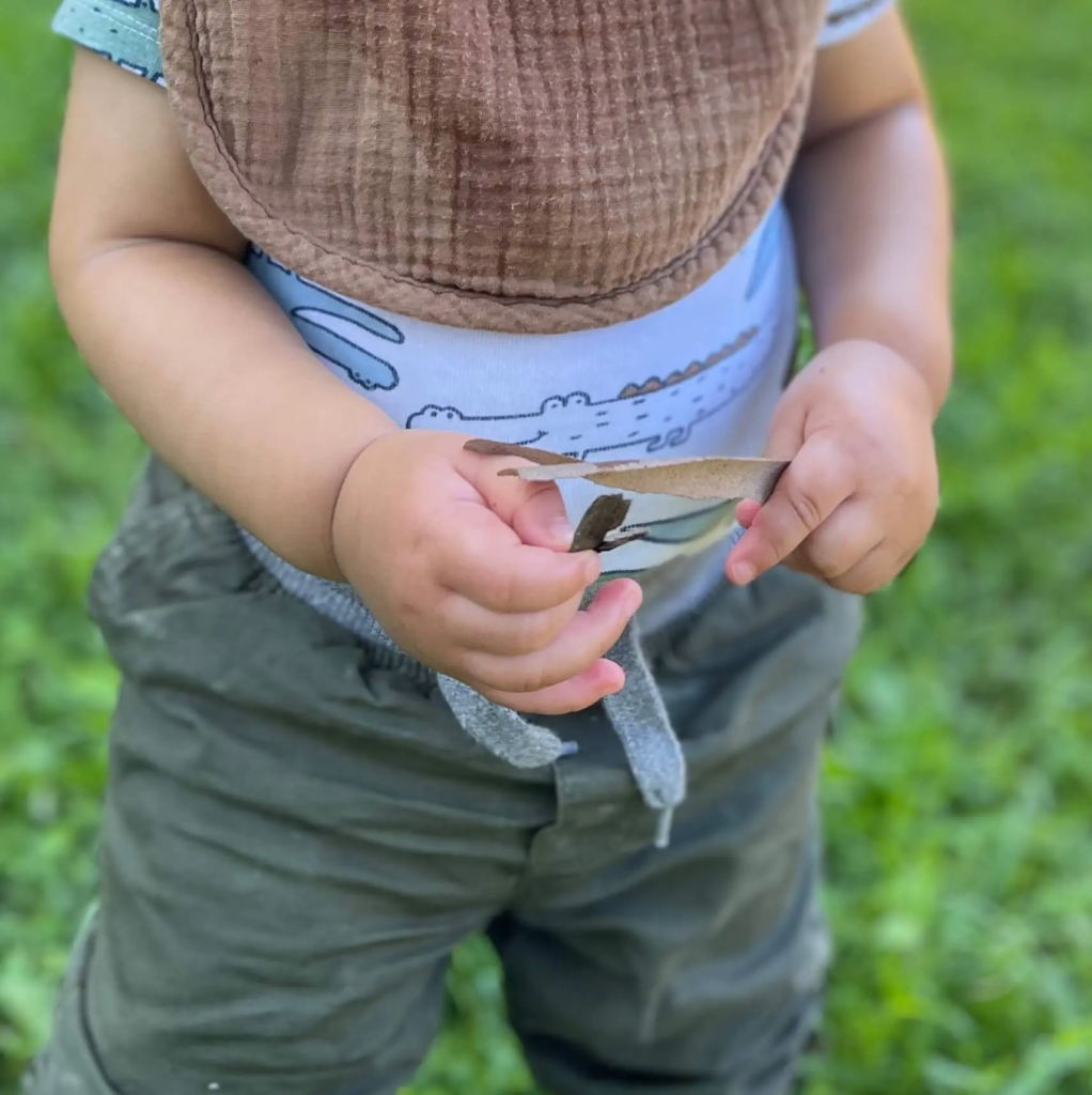 A young boy holding a handmade craft in his hands